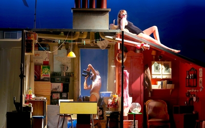 Sur une scène de théâtre, trois studios collés avec des personnes dedans