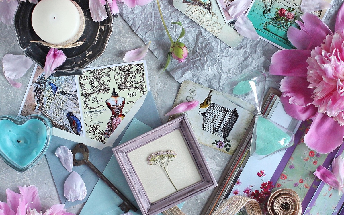 Des objets, images, dans un coloris pastel sont posés avec des fleurs