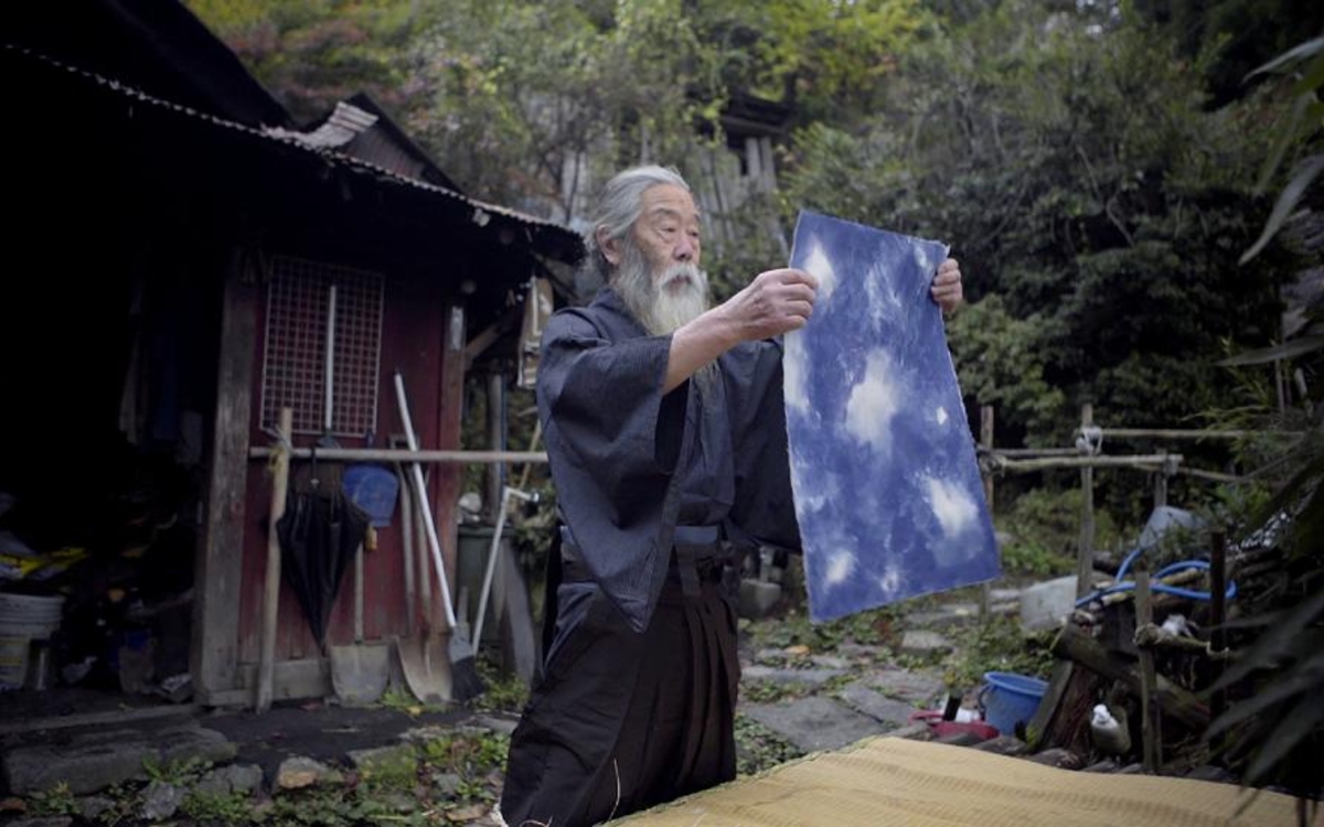Un samouraï âgé aux portes d'une maison en bois 