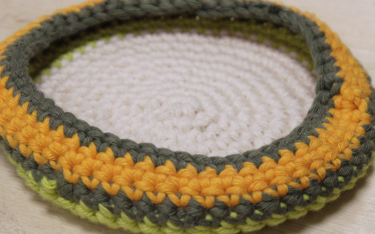 Photographie d’une panière tricotée en trapilho lors d’un atelier créatif.