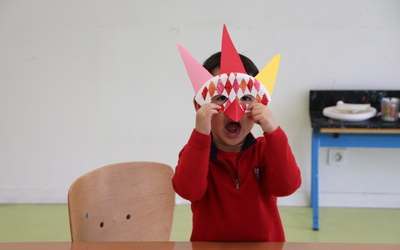 Un enfant avec un masque rit