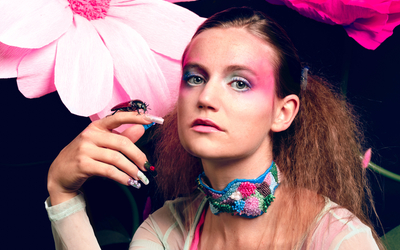 Sur fond noir, l'artiste Louisadonna avec un maquillage coloré