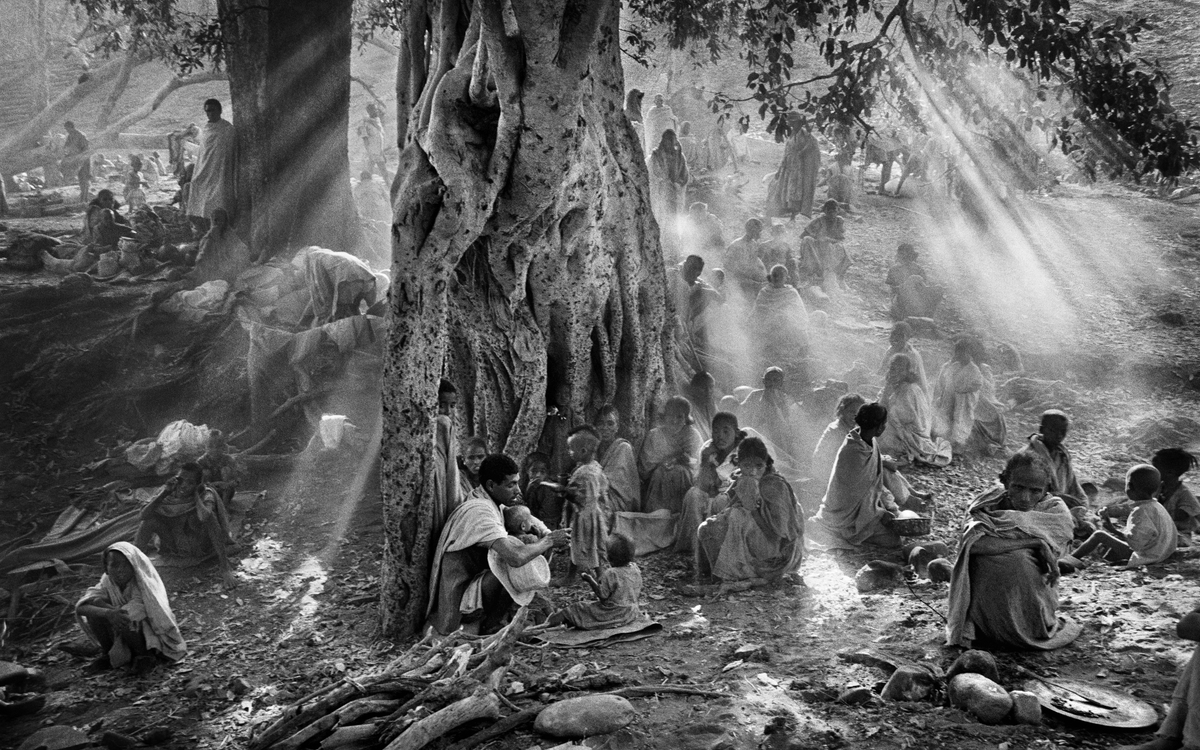 Dans le camp de Kalema, dans l'ouest du Tigré, des milliers de réfugiés arrivent après une marche de nuit pour éviter les mitrailleuses des Migs de l"armée éthiopienne. Éthiopie, 1985. 