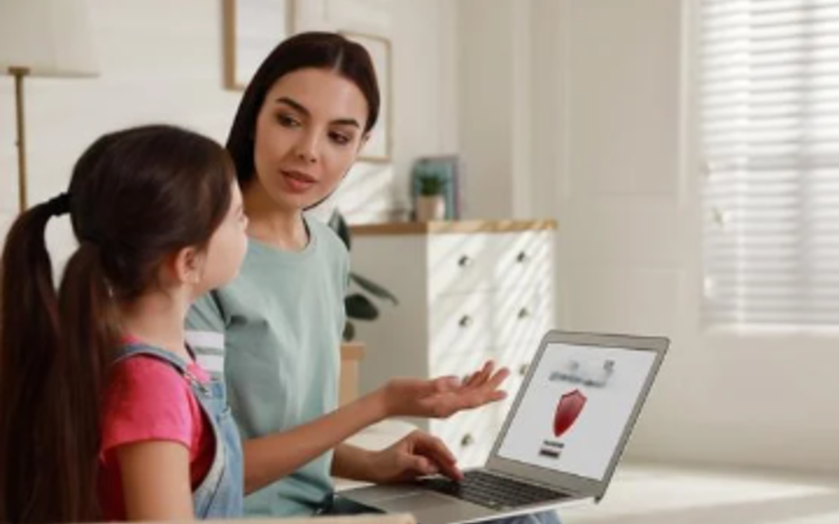 une femme explique à une petite fille en montrant un ordinateur