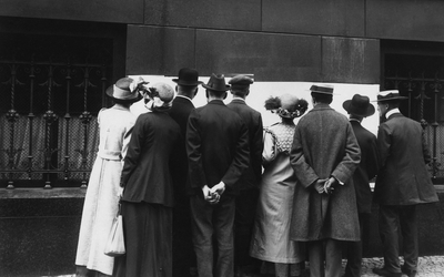 Photo en noir et blanc personnes rassemblées devant un tableau blanc