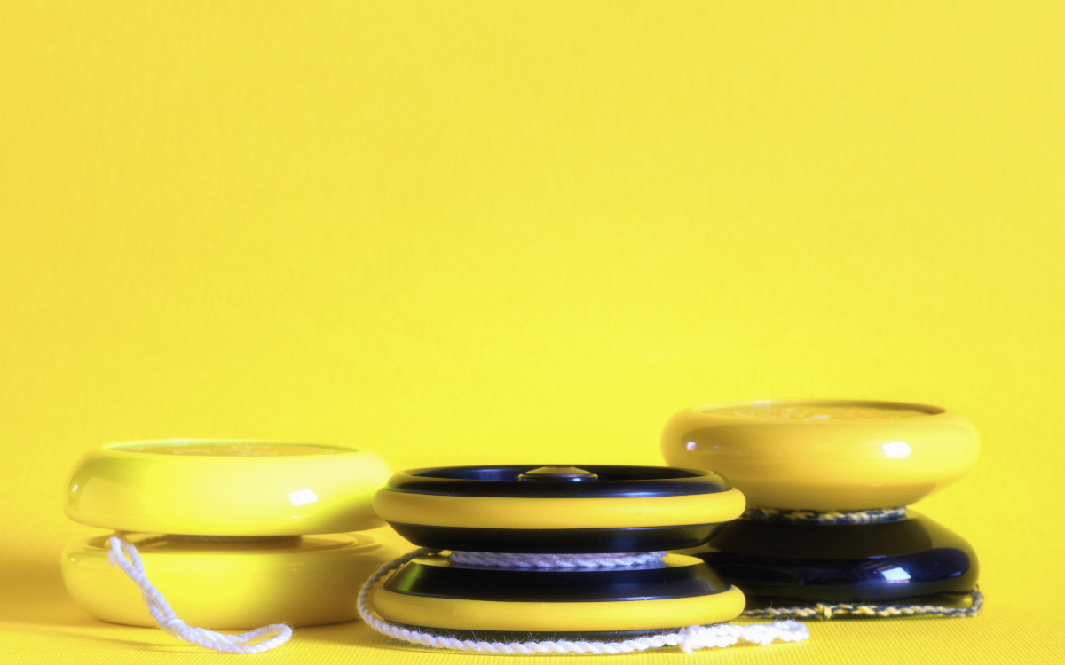 Trio de yoyo sur fond jaune.