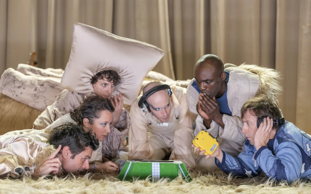 Autour d'un objet vert, plusieurs hommes semblent attentifs