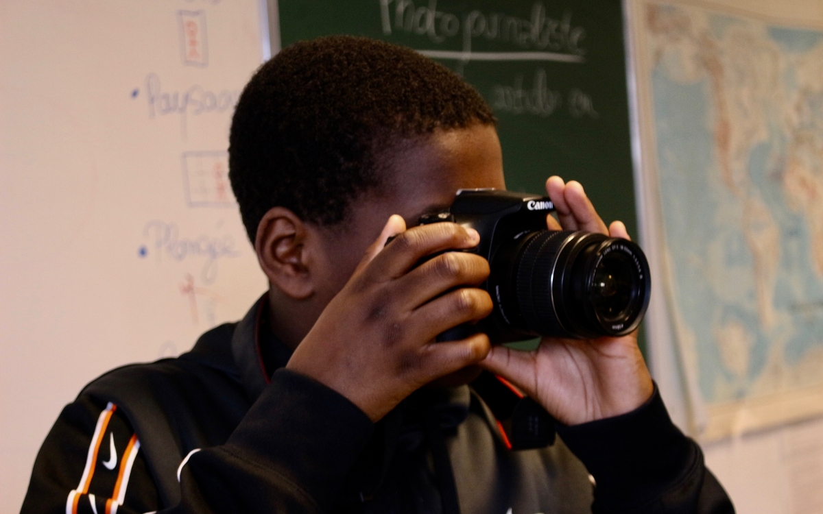 Un jeune garçon prend une photo prend une photo avec un appareil photo argentique.