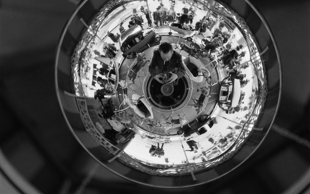 Image déformée d'un manège dans un miroir sphérique. France, vers 1937. © Gaston Paris / Roger-Viollet