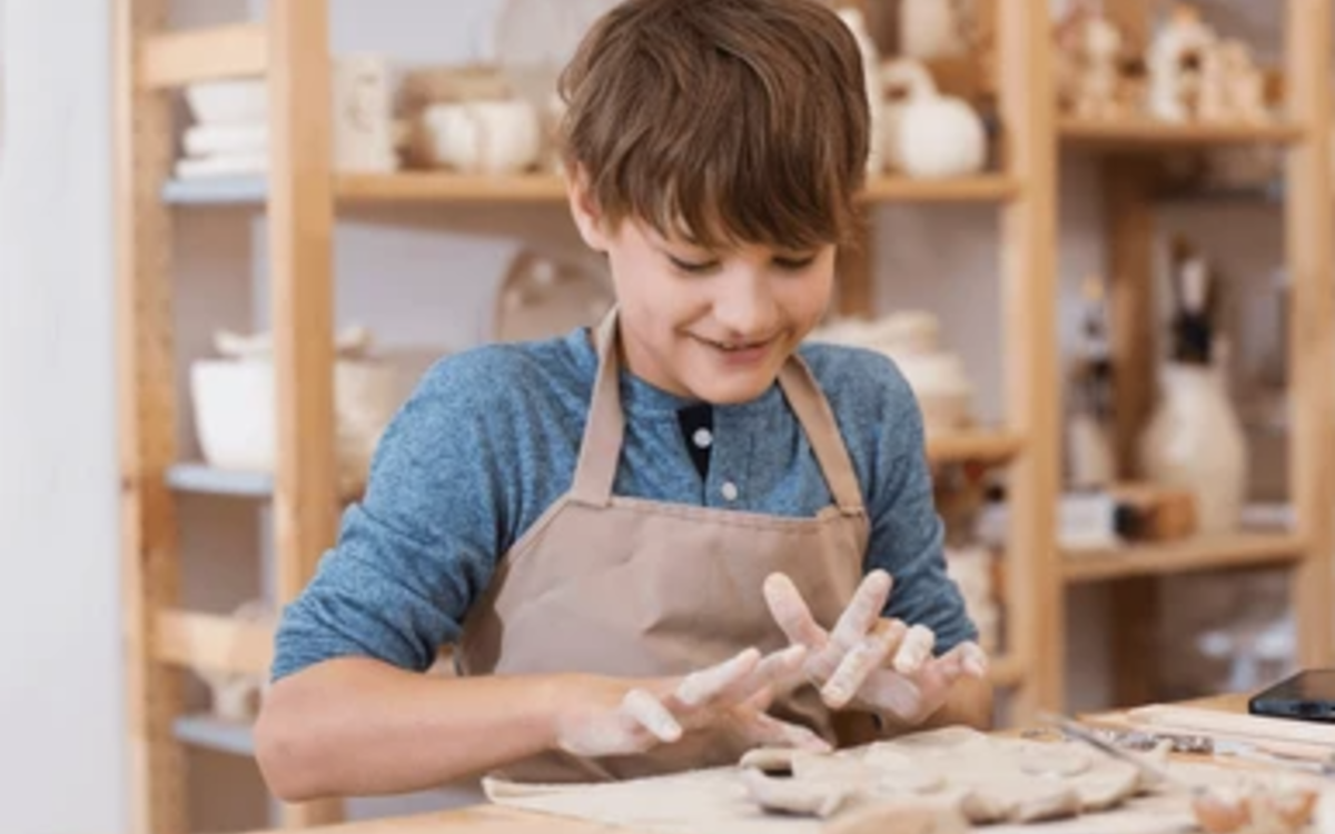 un enfant pétrie la terre et fabrique un objet