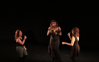 3 femmes chantent sur une scène