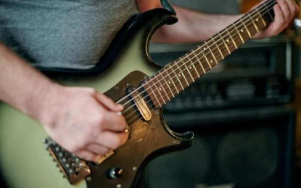 Une personne joue de la guitare électrique