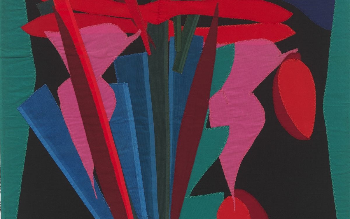 Textile au fond noir avec bandes de tissus colorés (rouges, roses, verts...) formant un motif végétal