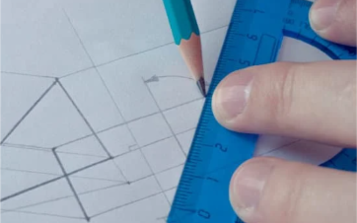 Un enfant dessine un plan avec un crayon 