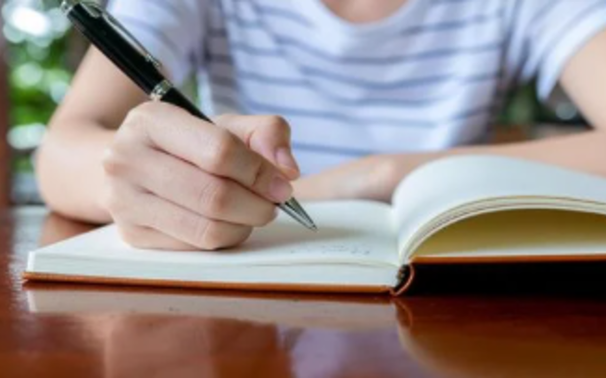 Une personne écrit dans un carnet