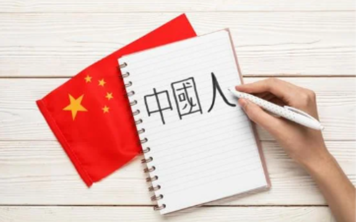 Une personne dessine des idéogrammes chinois sur un carnet