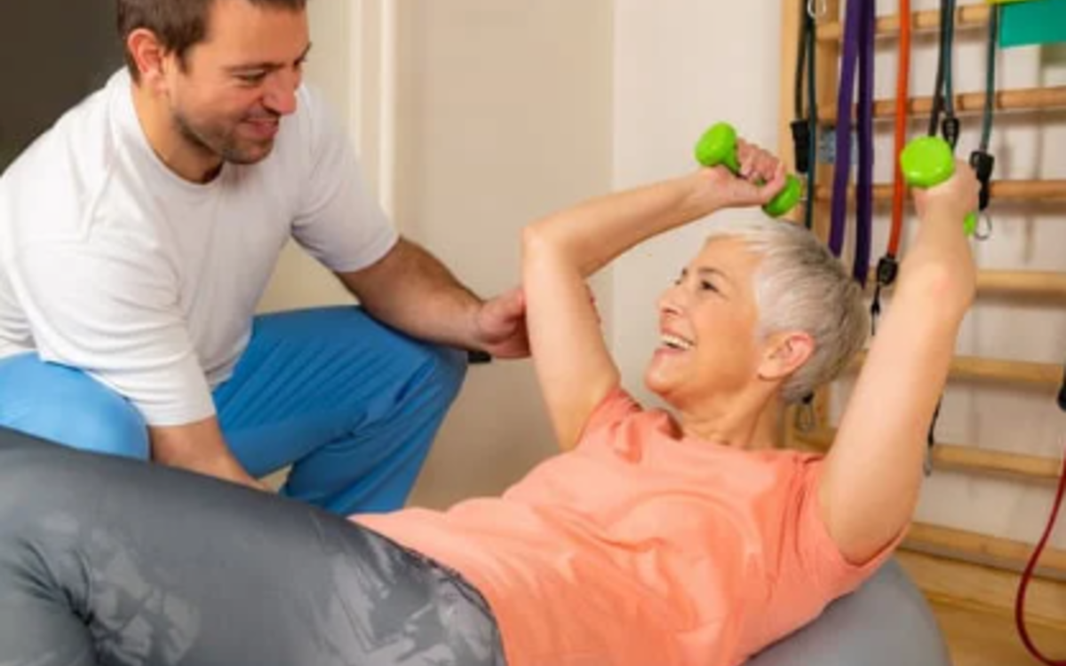 Une sénior fait de la gym douce avec un coach