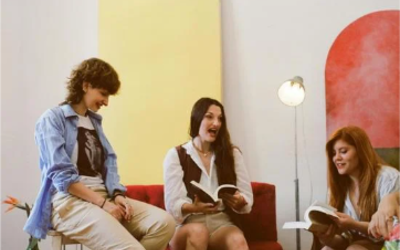 Des femmes apprennent l'espagnol à l'aide d'un livre, l'une d'elles parle