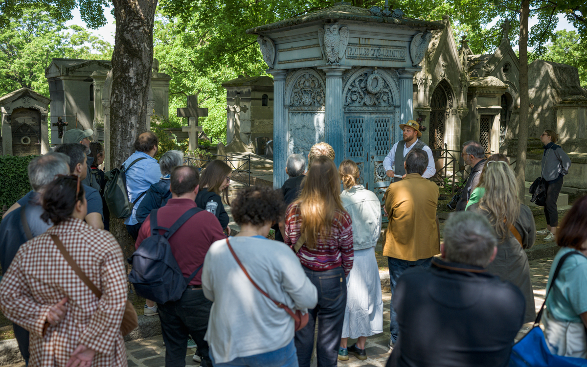 Groupe écoutant le conférencier devant une tombe