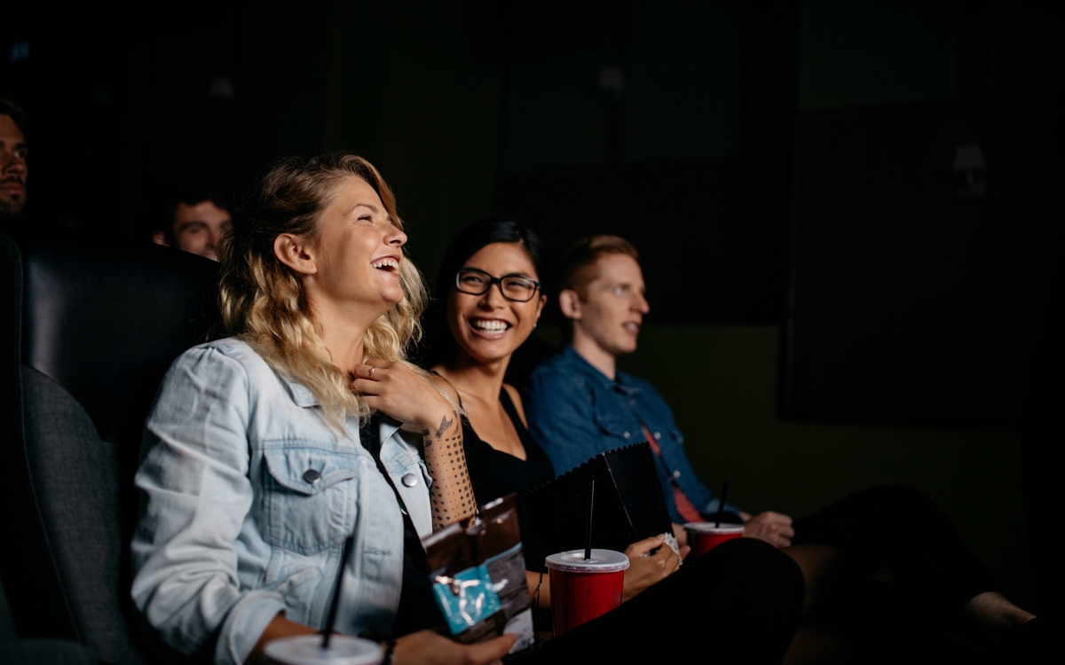 Femmes rigolant dans un cinéma