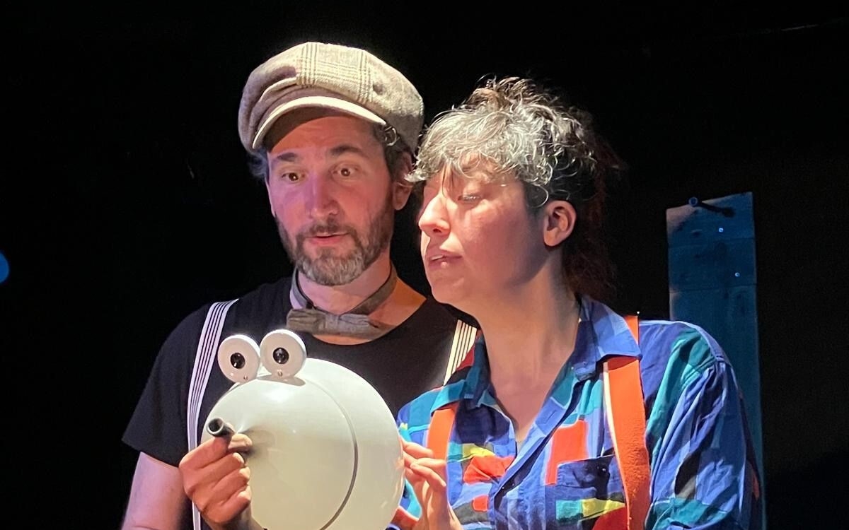 Deux personnes sur fond noir tiennent une souris en ballon