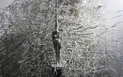 Oeuvre représentant une petite statuette pendue à un arbre