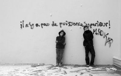 deux enfants devant un mur tagué " il n'y a pas de puissance supérieure"