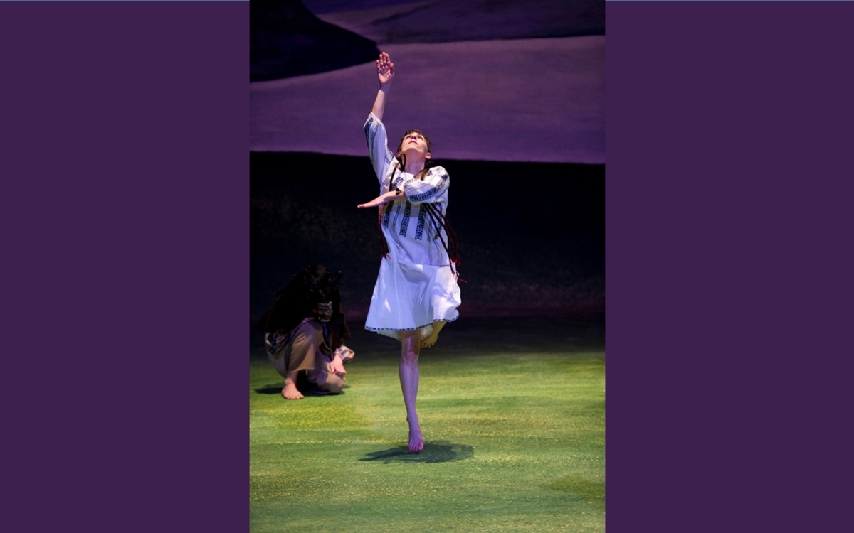 Une danseuse sur scène habillée en blanc 