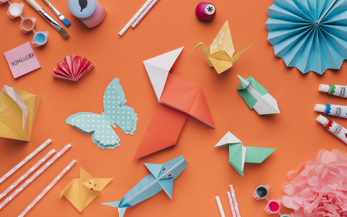 L'image représente des créations en papier de divers couleurs sur un fond orange