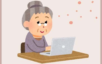 Image d'une dame âgée souriante devant un ordinateur portable