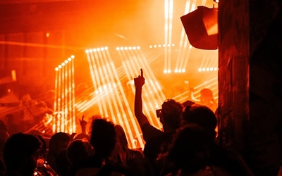 Photographie d'une foule dansant dans un club avec des lumières orange