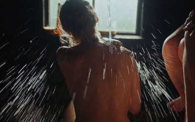 Une femme dénudée, de dos, dans un sauna estonien