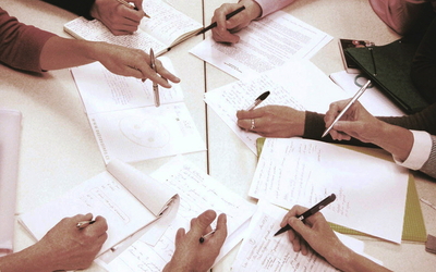 Mains, feuilles et crayons sur une table