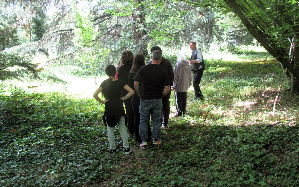 Groupe de personnes sous les arbres écoutant le conférencier