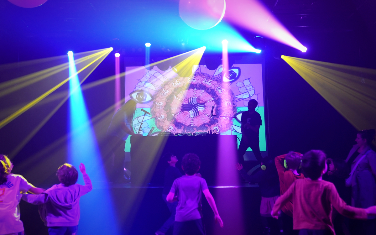 ambiance boite de nuits avec des lumières colorées et des enfants qui dansent