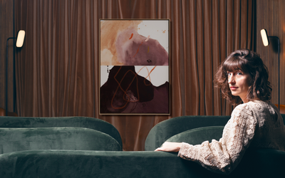 Charlène Delaville dans le salon privé de l’Hôtel Dame des Arts, devant une œuvre abstraite de l'artiste Julia A. Etedi lors d’une immersion artistique.