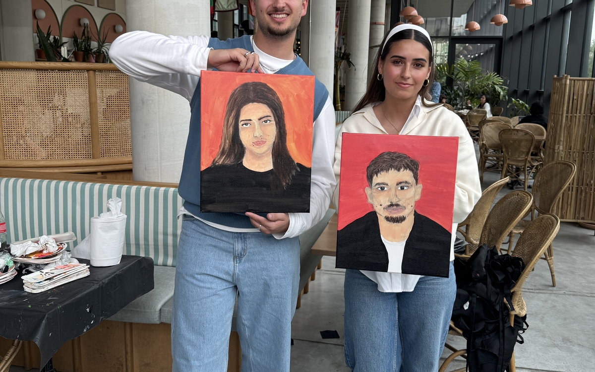 Personnes en train de peindre le portrait de leur partenaire lors d’un atelier créatif et convivial à Paris.