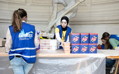 Dans un musée, des bénévoles distribuent de la nourriture à des étudiants