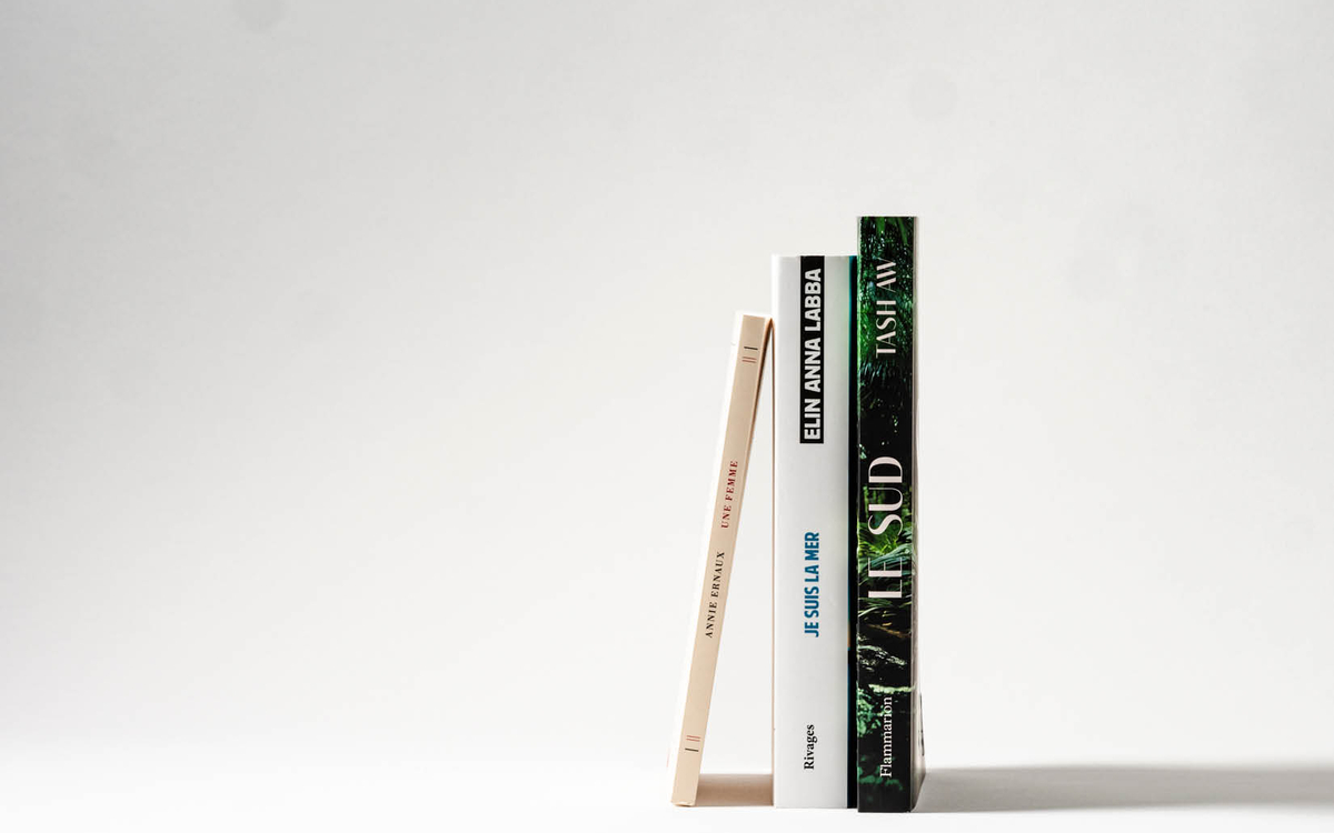 Trois livres (un de chaque écrivain présent de la rencontre) appuyés les uns contre les autres, en équilibre, sur fond blanc. 