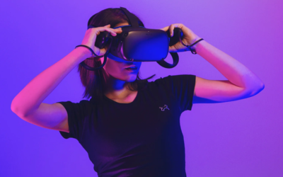 Une personne utilise un casque VR, sous un fond et une lumière violets