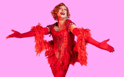 Laurent Lafitte, habillé en tenue de Cabaret qui se maquille devant un miroir lumineux
