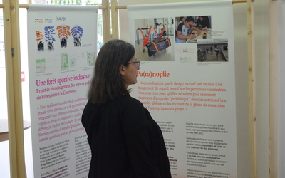 Une personne lisant un panneau dans l'exposition "de la fabrique des discriminations au design inclusif"
