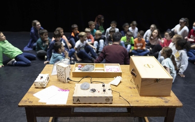 Table couverte d'objets insolites avec groupe d'enfants en arrière plan