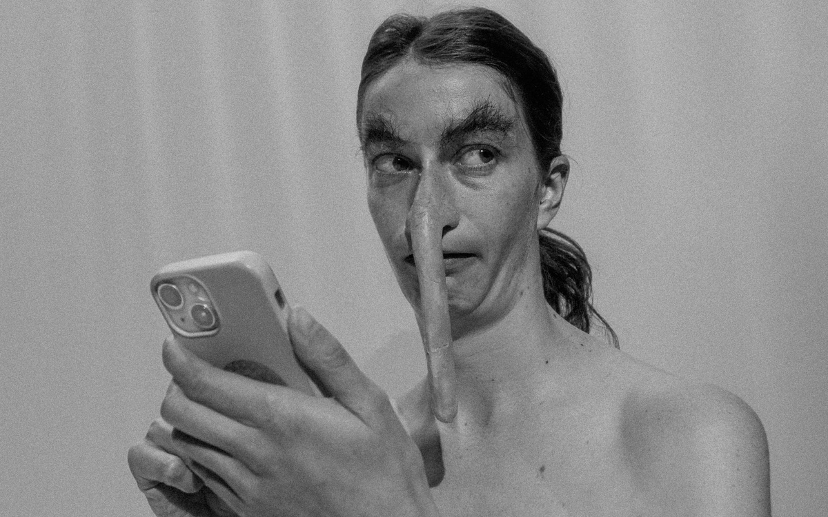 Personnage au nez déformé (très long et pendant) tenant un téléphone