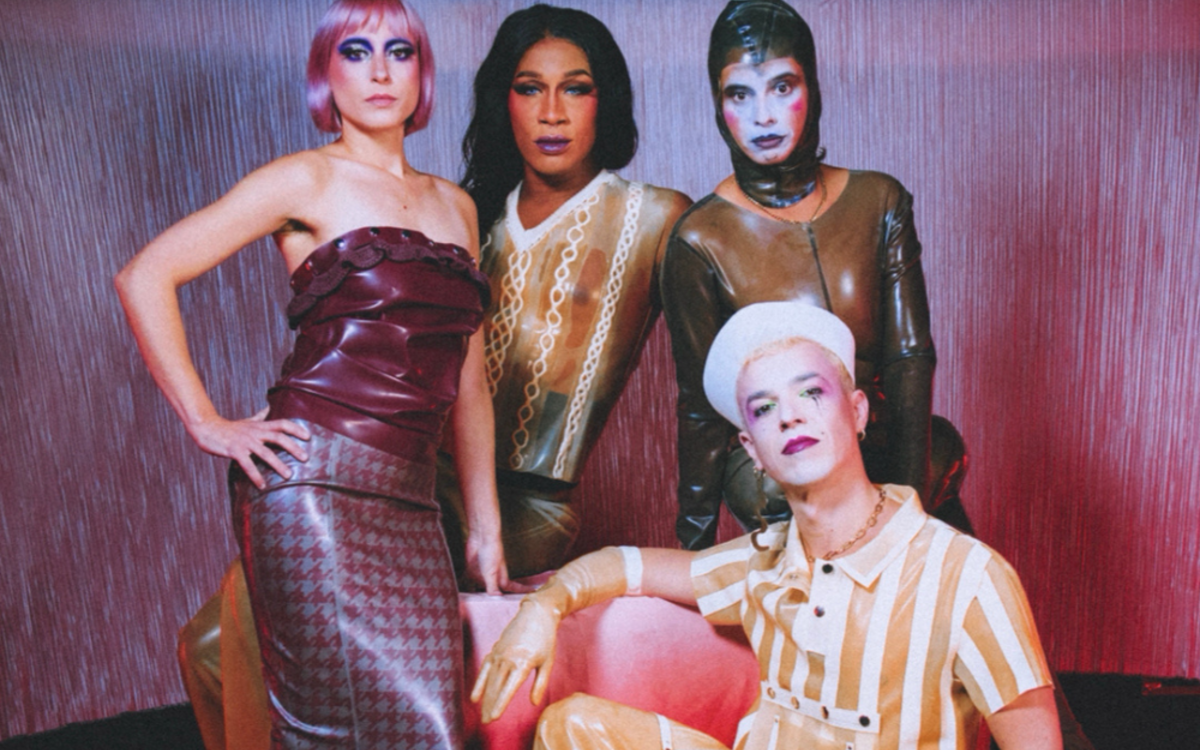 Les membres de la troupe La Bouche Cabaret posent devant un rideau irisé