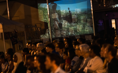 projection Ciné-Voisin.es la nuit, place Mouraud. Apparait derrière les spectateurs le reflet du projecteur
