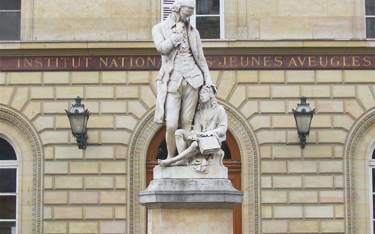 Statut blanche de Valentin Haüy devant la façade de l'inja louis braille.