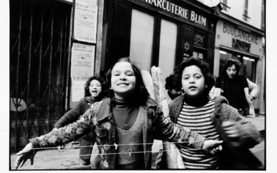 Photo en noir et blanc prise dans le Marais montrant des enfants qui courent en riant