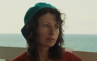 Marie Rivière dans "Le Rayon vert", un béret vert et un gilet rouge, le regard vague