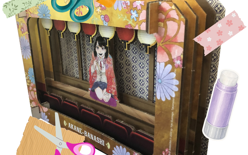Personnage manga au centre d'un décor en carton